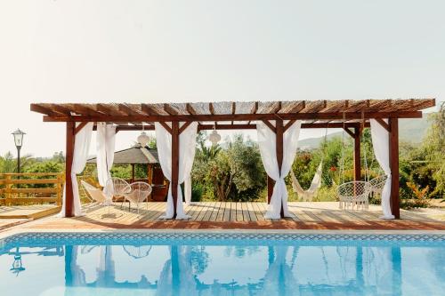a pool with a gazebo and a table and chairs at Quinta Bohemia in Moncarapacho
