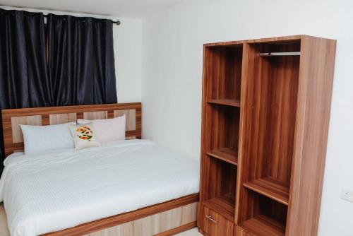 a bedroom with a bed and a wooden book shelf at William Ofori-Atta Fie in Accra