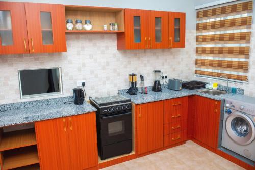 cocina con armarios de madera y horno con fogones en William Ofori-Atta Fie, en Accra