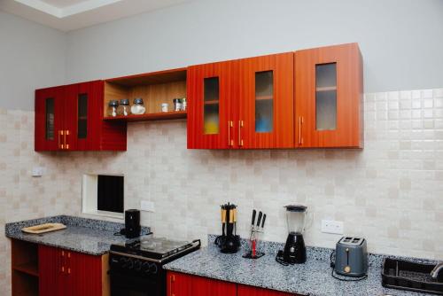 a kitchen with red cabinets and a counter top at William Ofori-Atta Fie in Accra