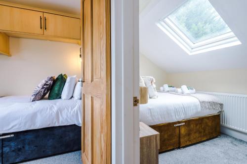 切斯特的住宿－Charming 3-Bed cottage in Chester, ideal for Families & Workers, FREE Parking - Sleeps 7，一间卧室设有两张床和天窗