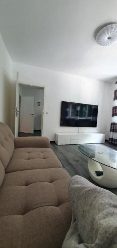 uma sala de estar com um sofá e uma televisão de ecrã plano em TLA TDY Ferienwohnung em Landstuhl