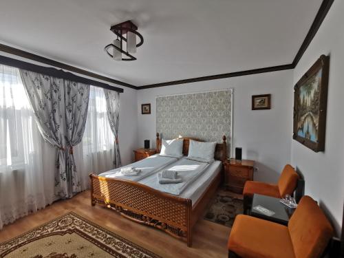 1 dormitorio con 1 cama grande y 1 silla en Casa cu Cerdac, en Sighişoara