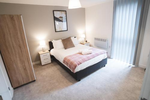 a bedroom with a bed and two lamps and a mirror at Birtin Works Apartments - Brand New - City Centre in Sheffield