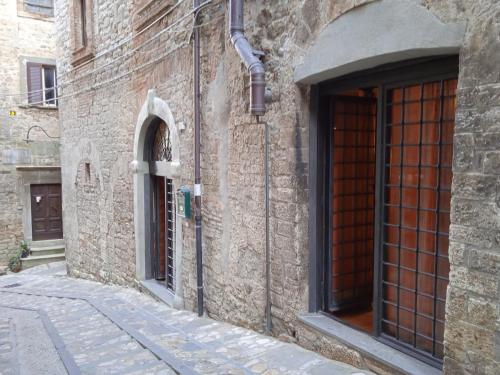 a stone building with a door and a street at Casa vacanza Todi Antica in Todi