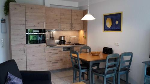 a kitchen with a table and chairs in a room at Landhaus am Haff_ Wohnung B 8 in Stolpe auf Usedom