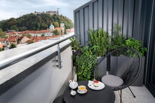 - un balcon avec une table et des chaises dans l'établissement City Hotel Ljubljana, à Ljubljana