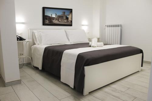 - une chambre dotée d'un lit blanc avec des draps noirs et blancs dans l'établissement Time B&B, à Poggiomarino
