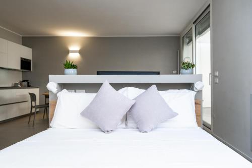 a bedroom with a white bed with white pillows at Viam Imbriani Suites in Rome