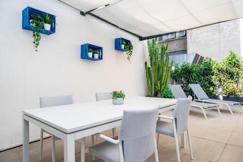 a white table and chairs on a patio with plants at Viam Imbriani Suites in Rome