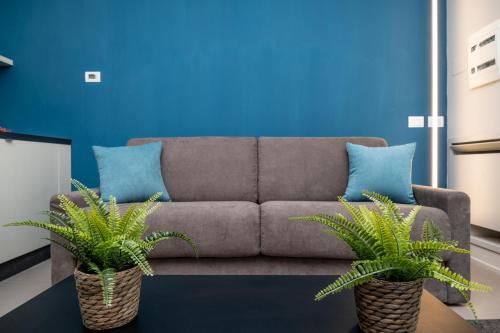 a living room with a couch and two plants at Viam Imbriani Suites in Rome