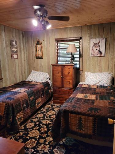 1 dormitorio con 2 camas y ventilador de techo en Butler's Bay Cottage cottage, en Hayward
