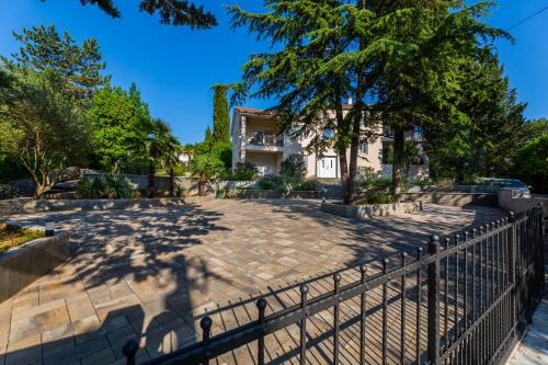 une terrasse en face d'une maison avec une clôture dans l'établissement Apartment Nada 2, à Malinska