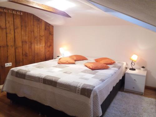 1 dormitorio con 1 cama grande con almohadas de color naranja en Apartmani Šišava Apt. Nancy, en Vlašić