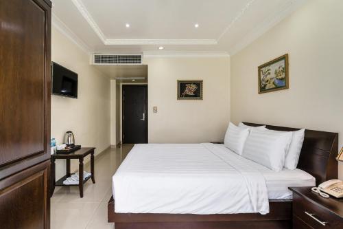 a hotel room with a bed and a telephone at La Bonita Hotel and Apartments in Ho Chi Minh City