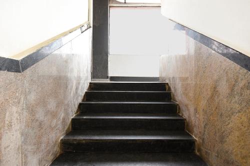 a staircase in a building with black steps at FabHotel High Rise - Marathalli in Bengaluru