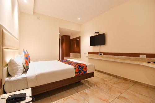 a hotel room with a bed and a flat screen tv at FabHotel High Rise - Marathalli in Bengaluru
