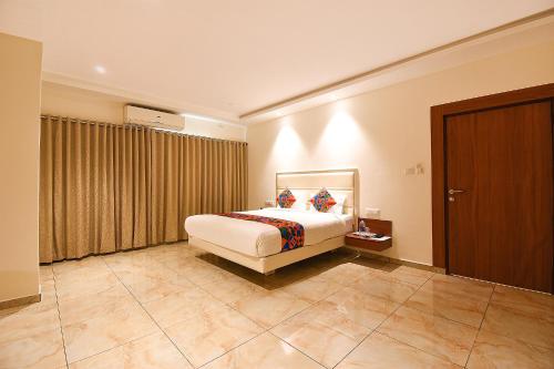 a hotel room with a bed and a window at FabHotel High Rise - Marathalli in Bengaluru