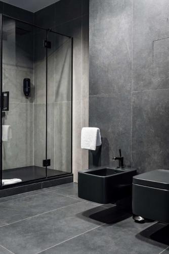a bathroom with a black sink and a shower at City Inn Lviv Smart Hotel in Lviv