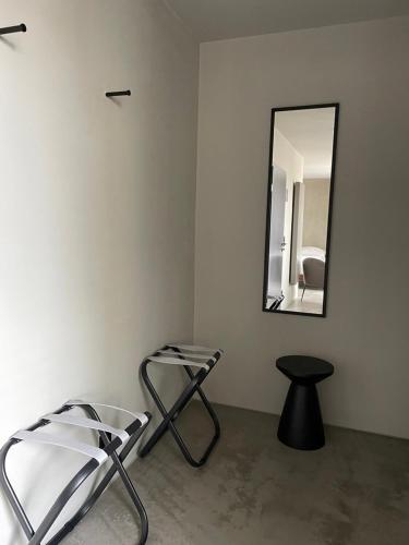 a room with a mirror and a chair and a stool at Hotel Mons am Goetheplatz in Munich