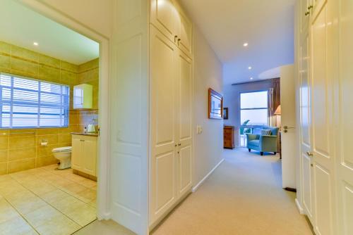 a bathroom with a hallway with a toilet and a sink at Plettenberg View in Plettenberg Bay