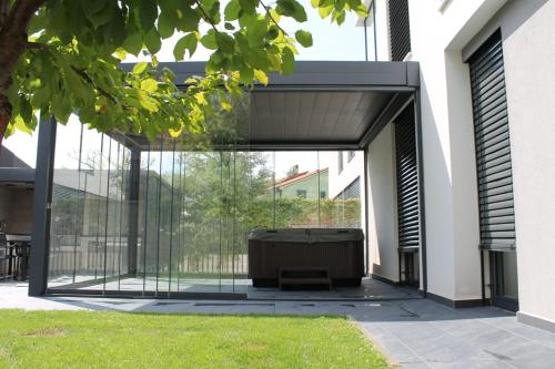 a glass extension of a house with a couch in a yard at Luxury Villa Ane in Malinska