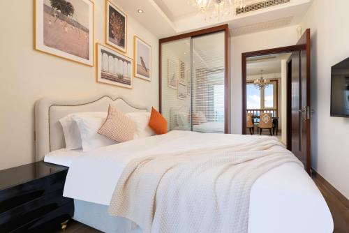 a bedroom with a large white bed and a window at Sanya Yikehai View Apartments in Sanya