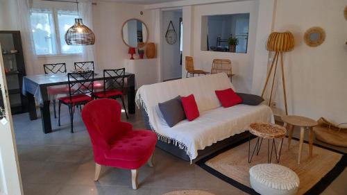 salon z kanapą i czerwonym krzesłem w obiekcie Casa Francesca w mieście Saint-Florent
