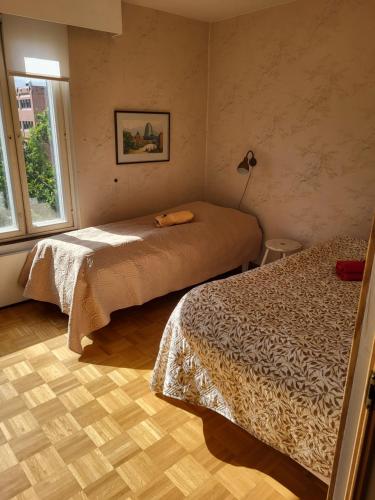 a hotel room with two beds and a window at Large apartment with 4 bedrooms, central location in Tampere