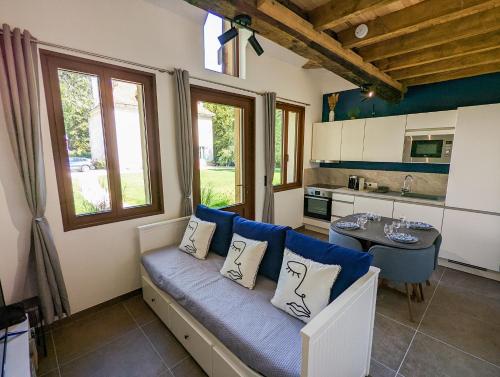 a living room with a blue couch and a table at La Maison T&M in Dosches