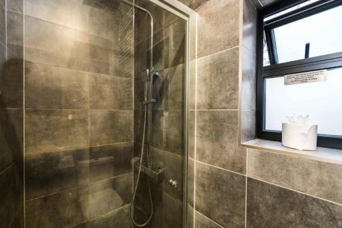 a shower with a glass door in a bathroom at 1 Bedroom House With an Edge in King Cross in London