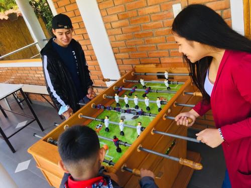 a woman and a boy playing with a chess game at Runaway Eco Hotel in Carhuaz