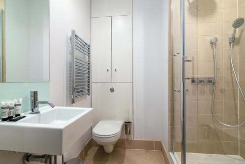 La salle de bains est pourvue d'un lavabo, de toilettes et d'une douche. dans l'établissement A Stunning Three Bedroom Home in Mayfair, à Londres