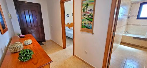 a room with a wooden table and a bathroom at Holiday flat BLUE OCEAN, beachfront, sea view, 1 bedroom, livingroom, fast internet in Costa Calma