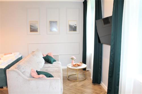 uma sala de estar com um sofá e uma mesa em JODEŁKA Apartament & Studio em Świeradów-Zdrój