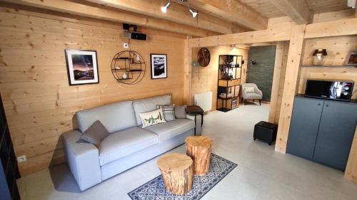 sala de estar con sofá y paredes de madera en Valley Lodge, en La Bresse