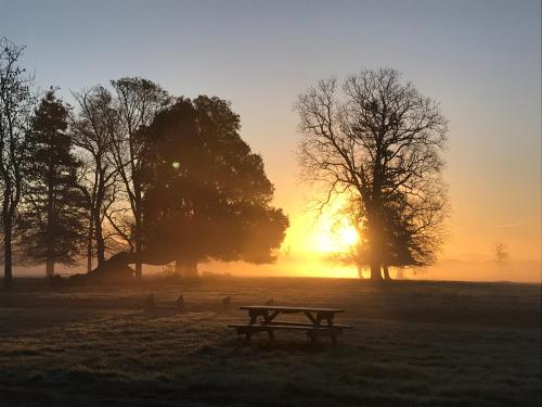 una mesa de picnic en un campo al atardecer en The Stables at Henham Park, en Southwold