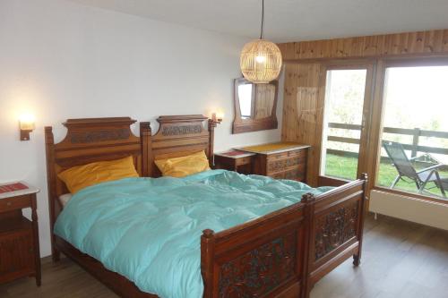 Un dormitorio con una gran cama de madera con sábanas azules en Oree du Bois OB D0 CALM apartment 6 pers, en Veysonnaz