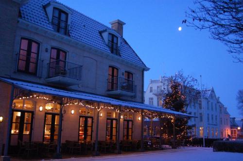 a building with a christmas tree in front of it at Hotel Graaf Bernstorff in Schiermonnikoog