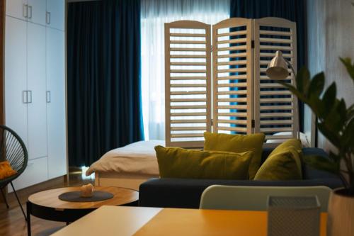 een woonkamer met een bank en een bed bij Boulevard Studio Apartment in Novi Sad