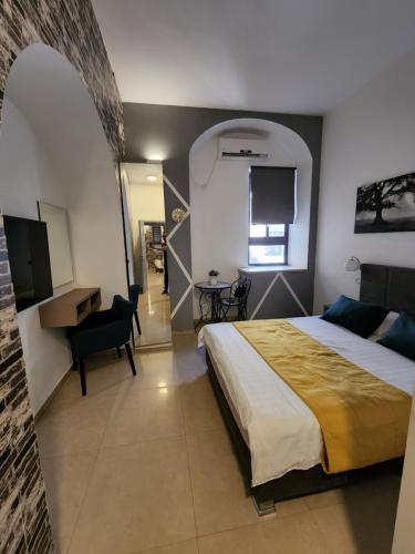 1 dormitorio con cama, escritorio y silla en Ben Hillel Boutique Hotel, en Jerusalén