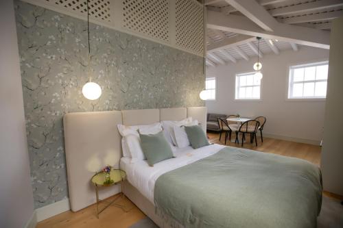 a bedroom with a large bed and a dining room at Trovador Guest House in Guimarães