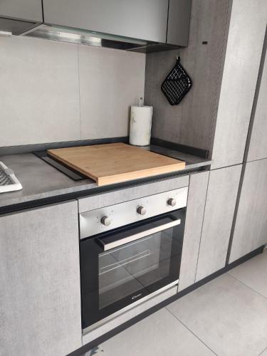 a kitchen with a cutting board on top of a stove at Bilocale in residence vista lago con piscina in Polpenazze del Garda