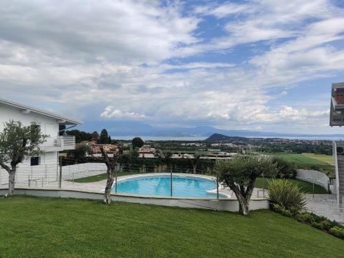 ポルペナッツェ・デル・ガルダにあるBilocale in residence vista lago con piscinaのスイミングプール付きの庭の景色を望めます。