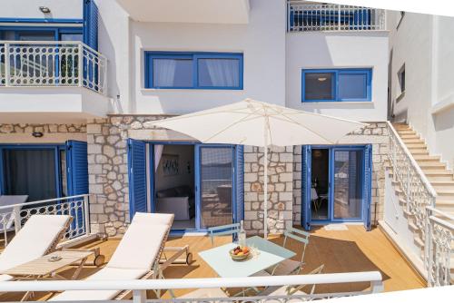 un patio con mesa, sillas y sombrilla en Greek Beach House A2 Lefkada, en Nydri