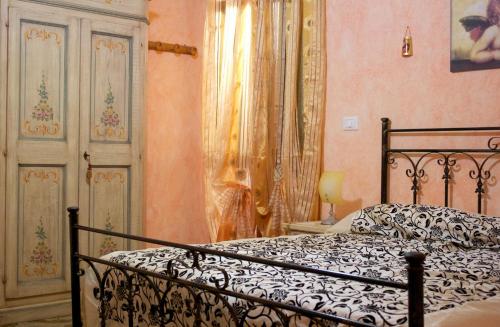 リド・マリーニにあるLido Marini Apartmentsのベッドルーム1室(ベッド1台、窓、カーテン付)