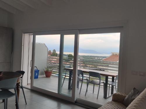 a living room with a sliding glass door to a balcony at Bilocale in residence vista lago con piscina in Polpenazze del Garda