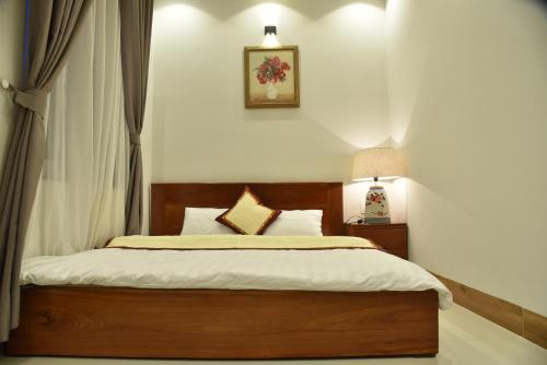 a bedroom with a bed with a wooden head board at Đà Lạt Villa 84 Hồ Xuân Hương in Da Lat