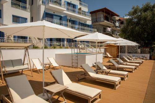 una fila de tumbonas y sombrillas en una terraza en Greek Beach House A2 Lefkada, en Nydri