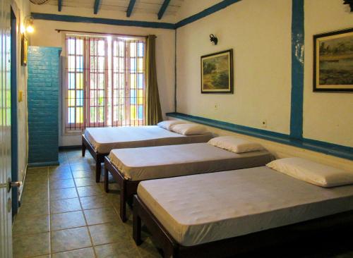 a row of beds in a room with a window at Casa com saida privativa para a Praia do Felix SP in Ubatuba